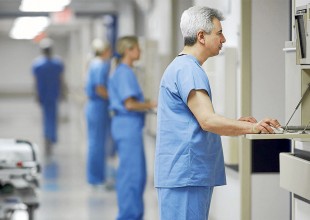 Hispanic male doctor looking at computer